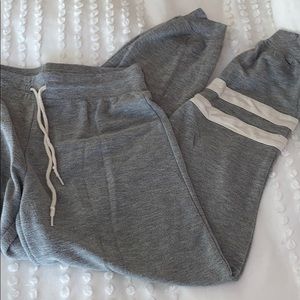 light gray sweat with two white stripes near 🦶🏼